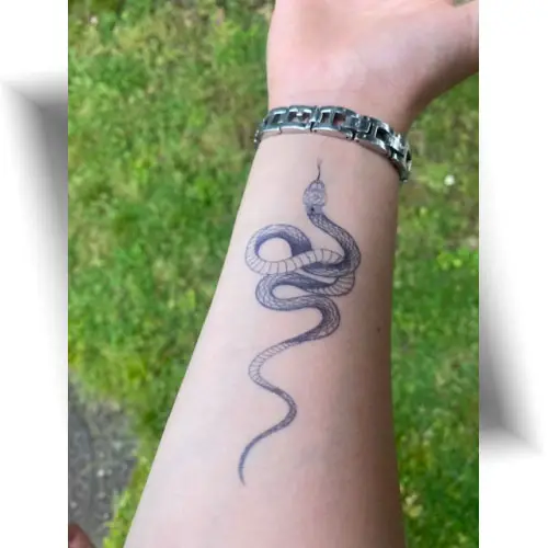 Le tatouage semi-permanent petit serpent au jagua : un rendu bleu nuit réaliste pour un look symbolique qui tient jusqu'à 15 jours.
