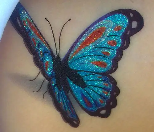 Tatouage éphémère papillon pailleté bleu, avec un design scintillant. Facile à appliquer, ce tatouage apportera une touche colorée à votre style.