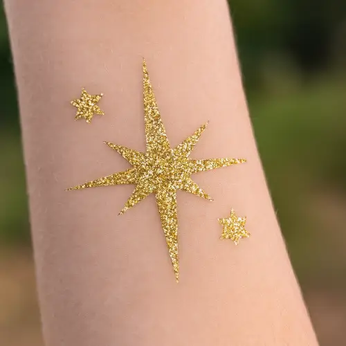 Tatouage temporaire en forme d’étoile réalisé avec des paillettes scintillantes, d’un pochoir adhésif et de la colle spéciale pour la peau.
